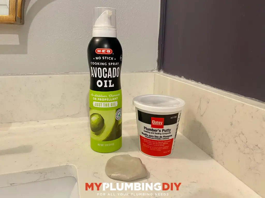 Spray oil and plumbers putty container with plumbers putty next to it